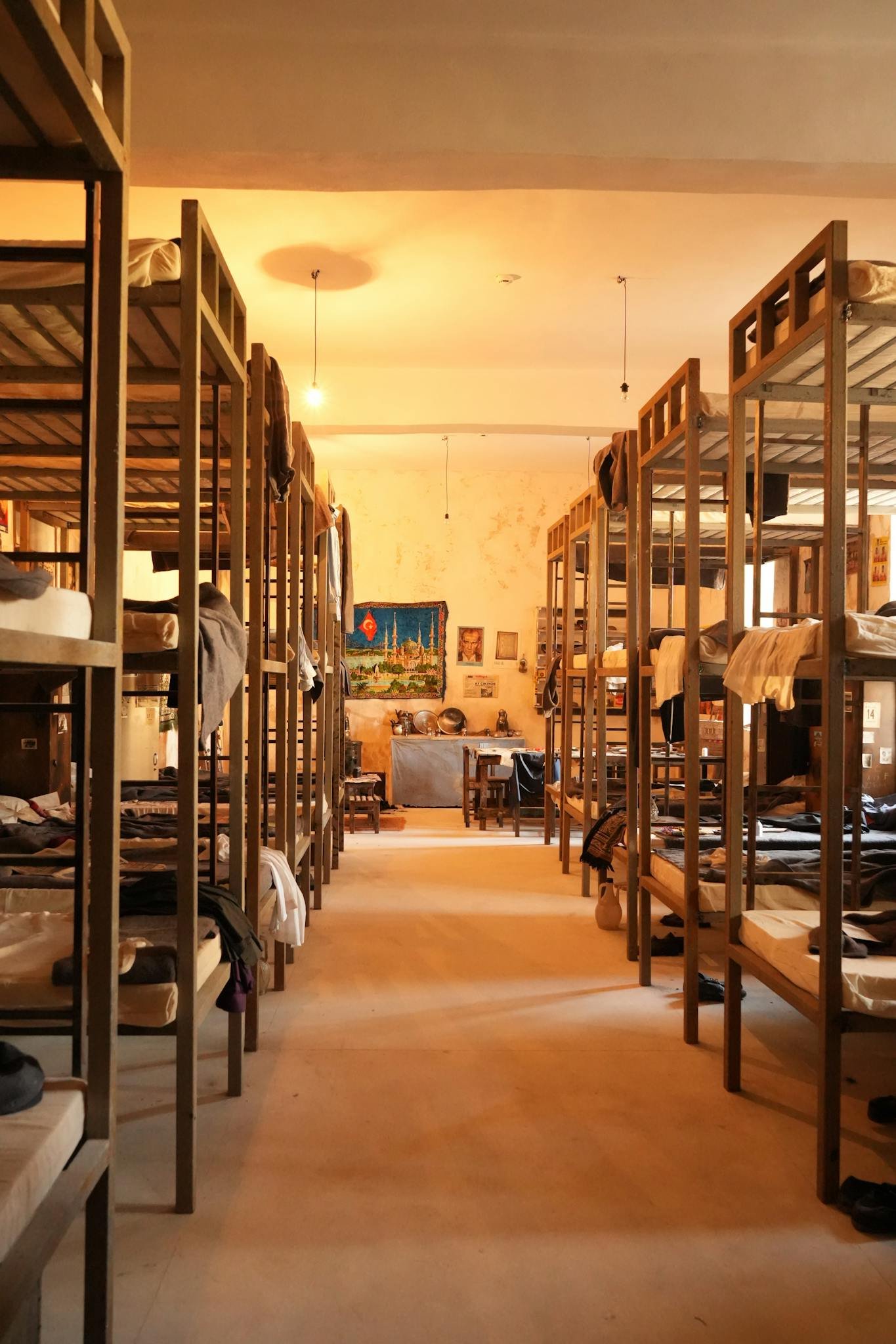 Warmly lit dorm room with wooden bunk beds and cozy atmosphere.